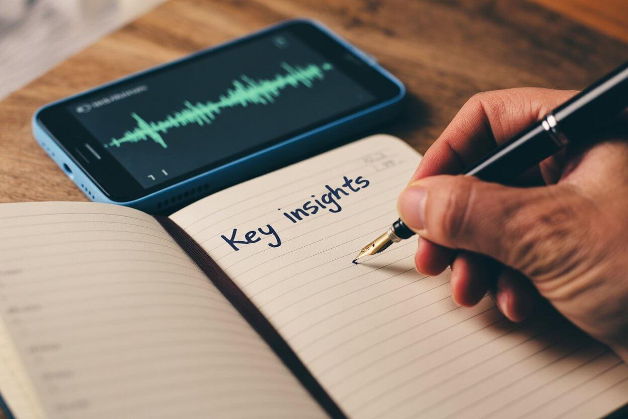 Notebook and pen next to a smartphone showing Active Listening setup
